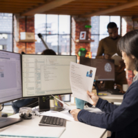 Tech startup HR senior manager vetting software development position applicants, ensuring their skills are strong enough match for role. Asian recruiter assessing candidate work experience, reading CV
