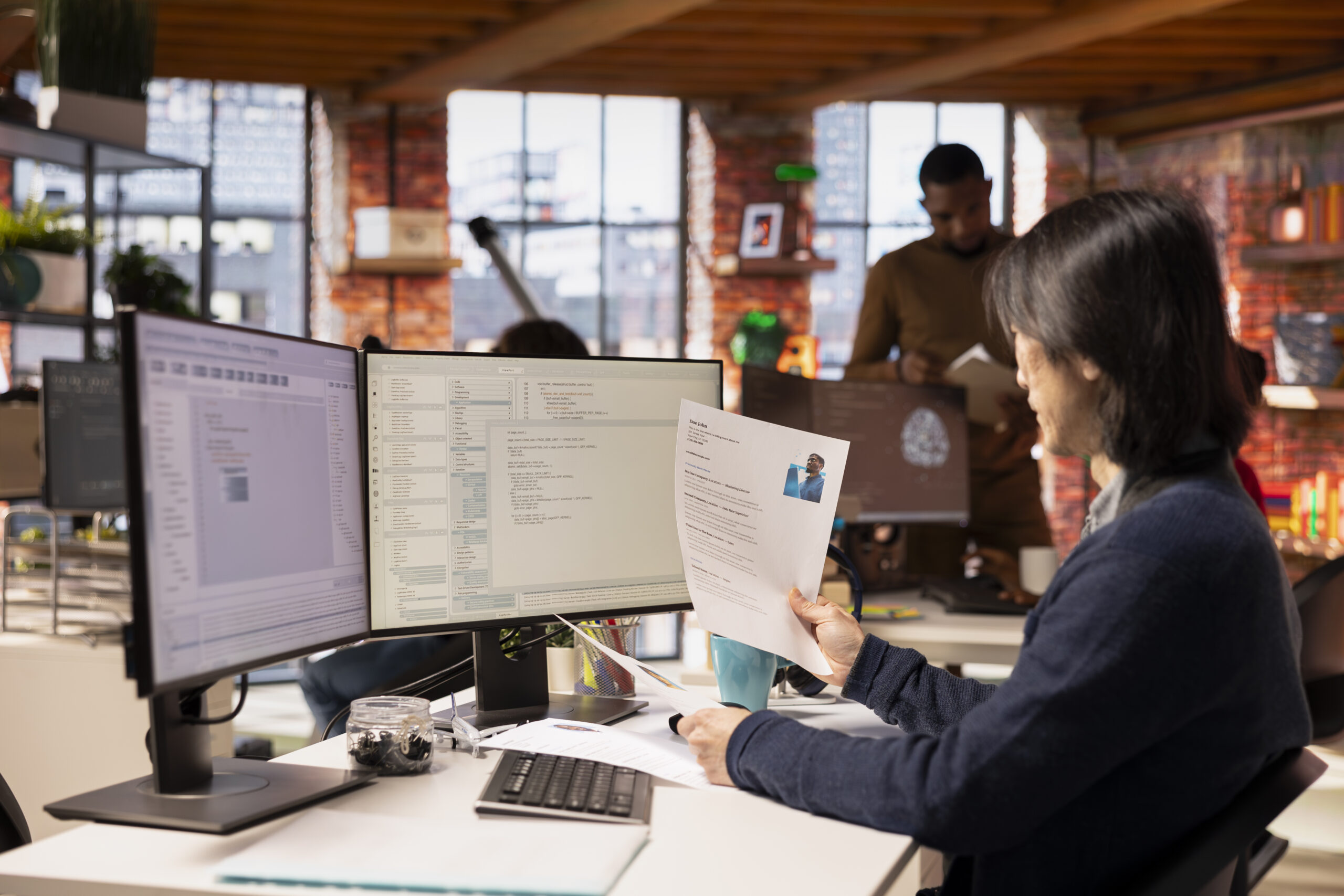 Tech startup HR senior manager vetting software development position applicants, ensuring their skills are strong enough match for role. Asian recruiter assessing candidate work experience, reading CV