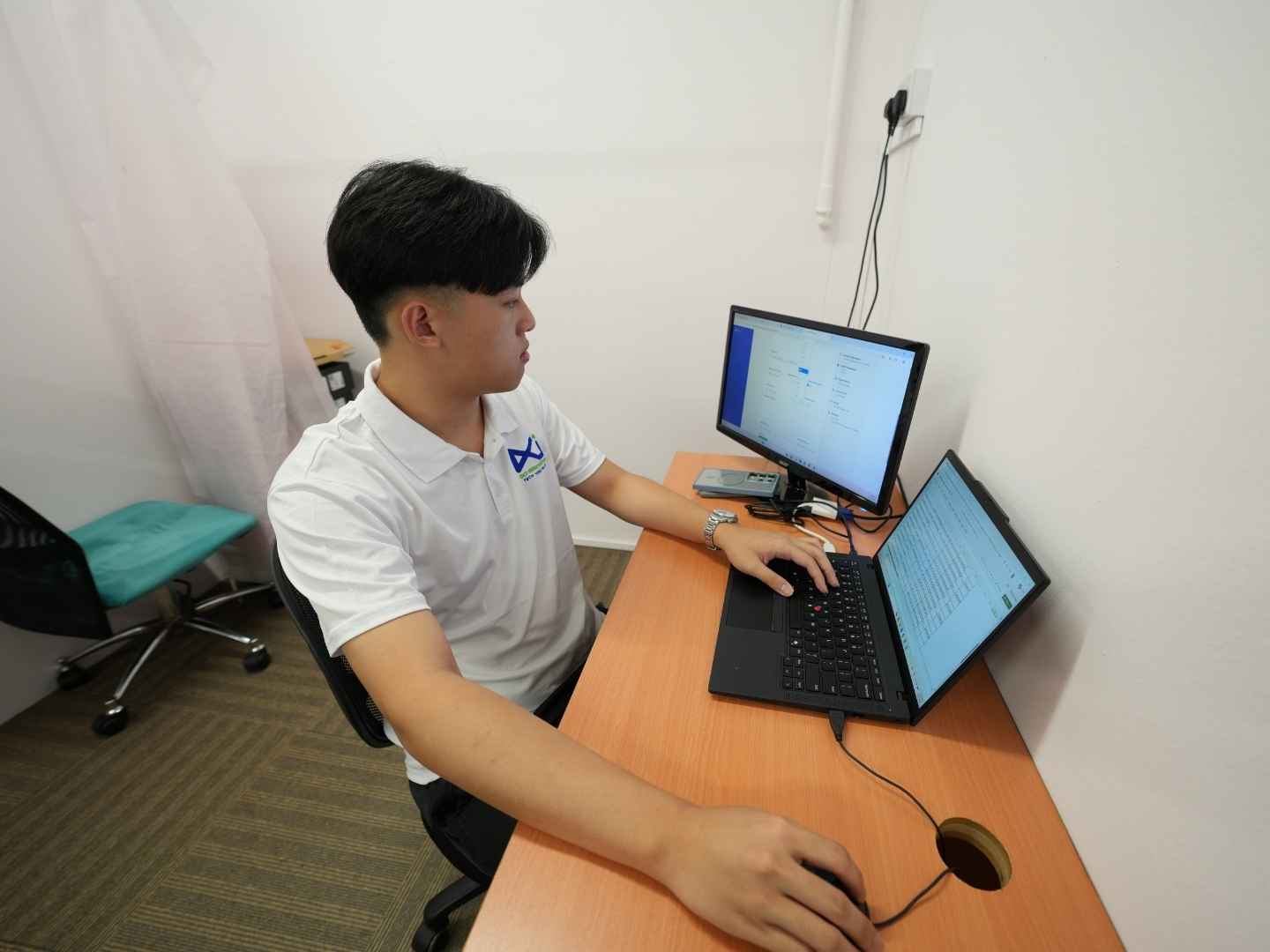 Cloud engineer managing cloud infrastructure and server dashboards on a desktop computer